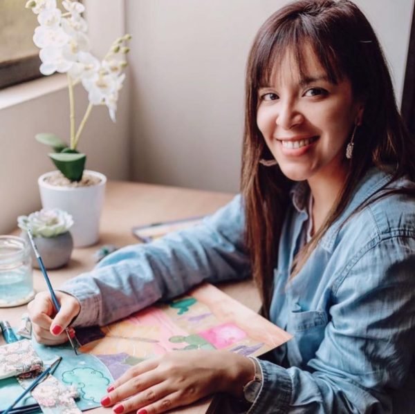 Artista Elizabeth Landeo pintando aquarela en una hoja de papel